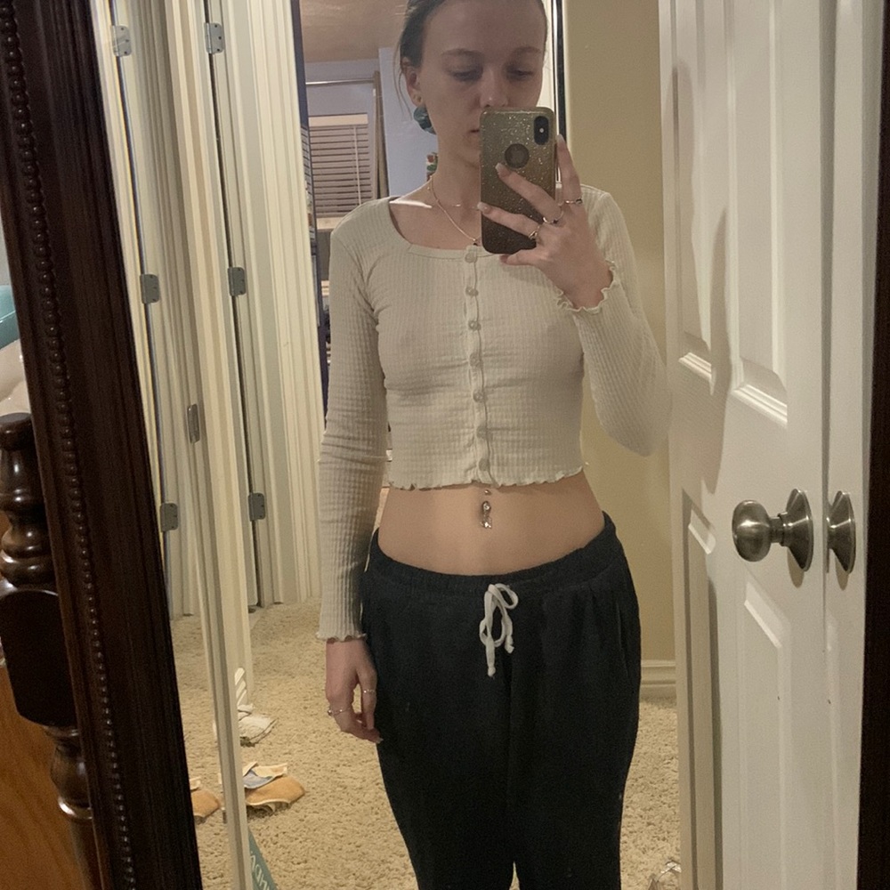 Beige colored crop top with long sleeves.